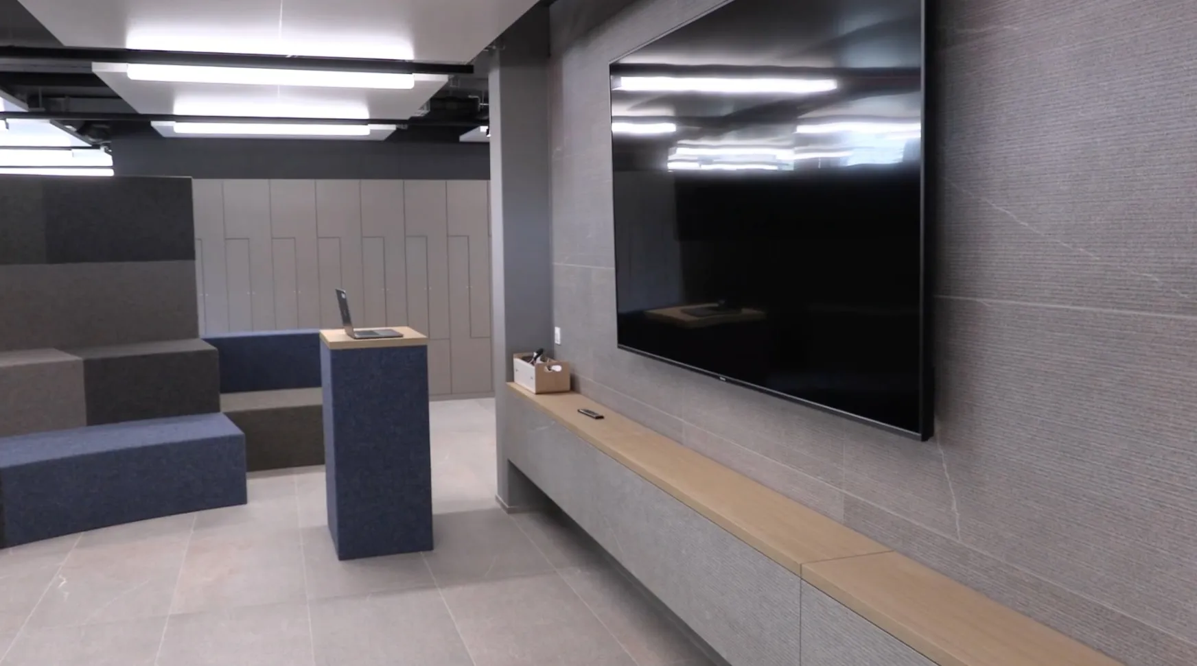 Die Präsentationsseite der Arena: grosser Bildschirm an der Steinwand, davor ein Rednerpult mit Laptop