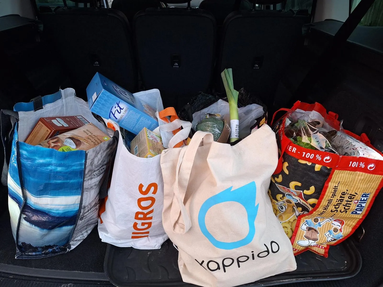 Kofferraum voller Einkaufstaschen, darunter eine xappido-Tasche