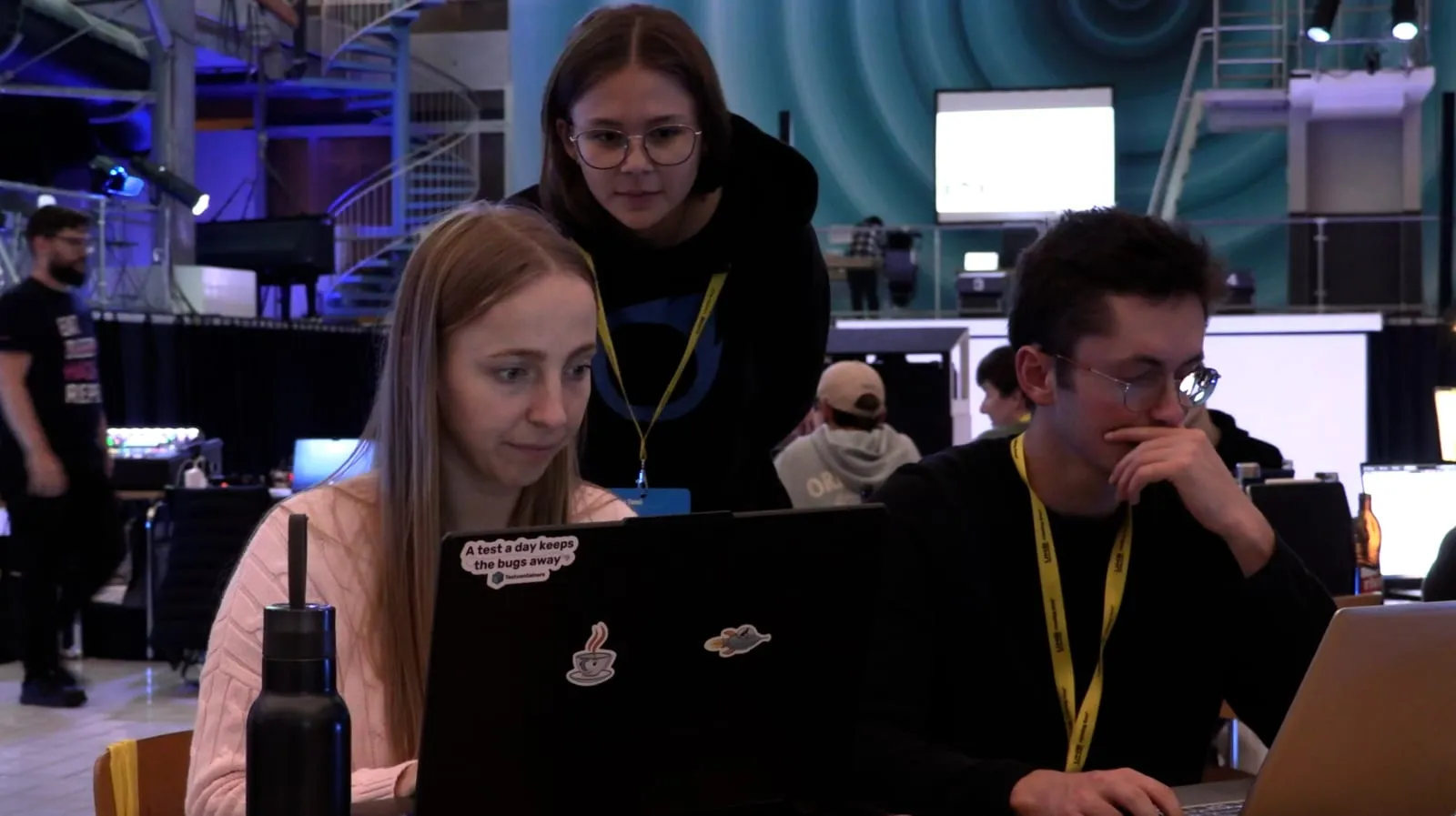 Betreuung am Hackathon: drei Personen arbeiten gemeinsam am Laptop