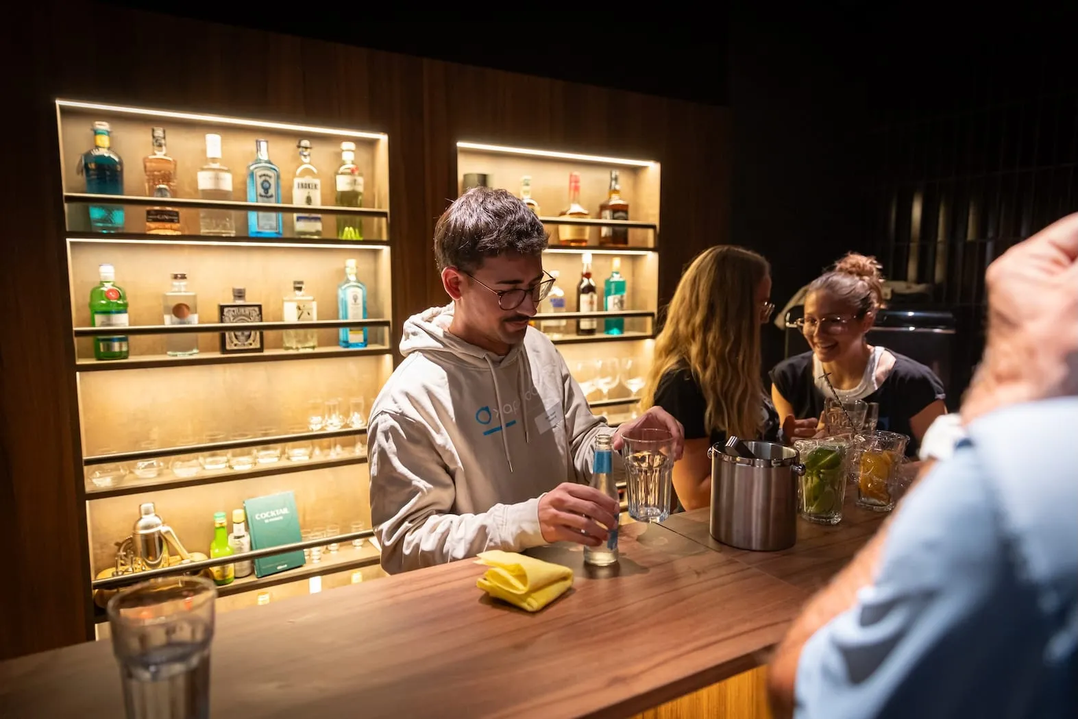An der Bar: Gäste stossen mit Getränken an