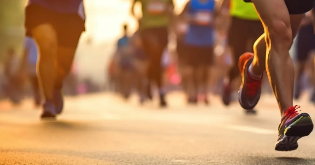 Beine von Läuferinnen und Läufern im Marathonfeld, im Gegenlicht