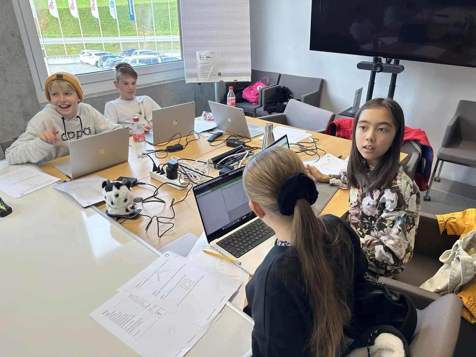 Teilnehmende programmieren an Laptops im Sitzungszimmer