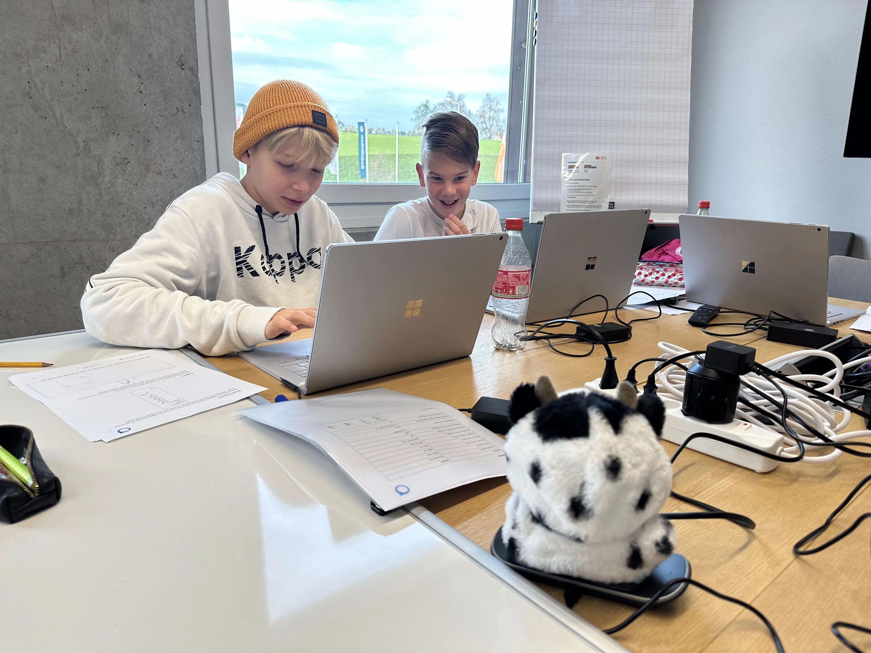 Mehrere Laptops und ein Lernroboter auf dem Arbeitstisch