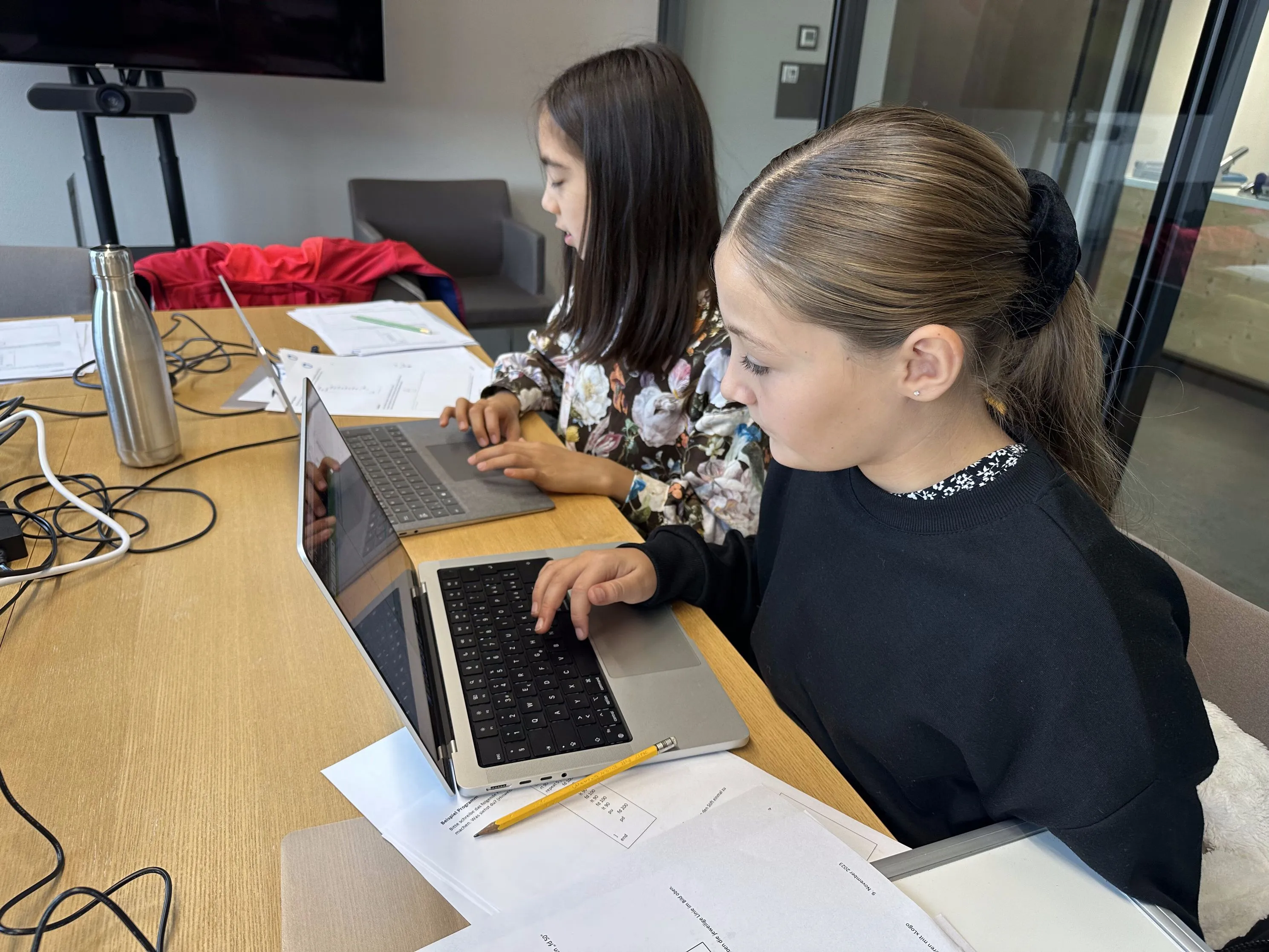 Zwei Schülerinnen programmieren gemeinsam an einem Laptop