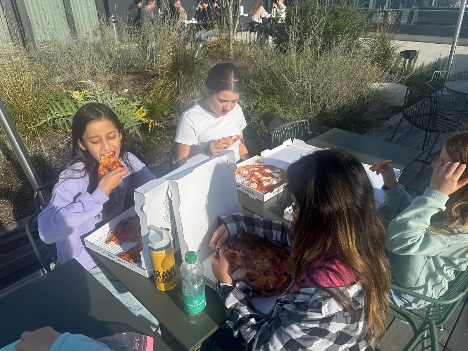 Gemeinsames Pizza-Essen im Innenhof des Büros