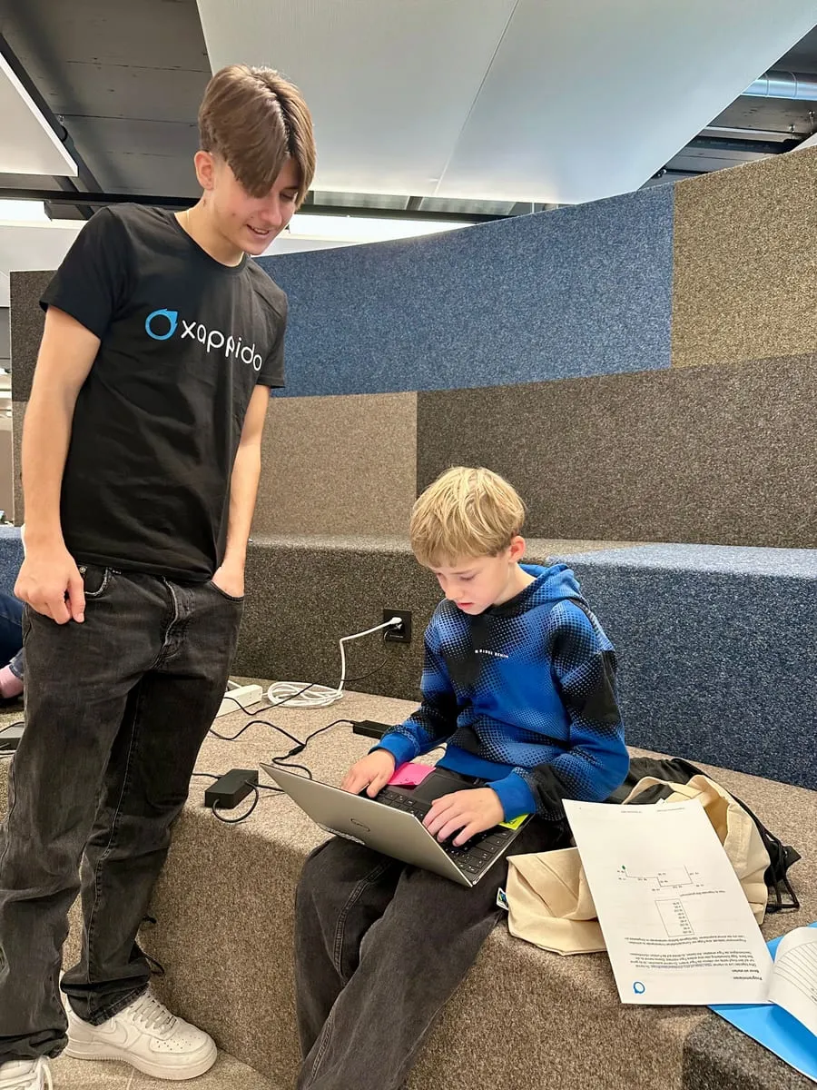 Ein xappido-Mitarbeiter unterstützt einen Jugendlichen beim Programmieren