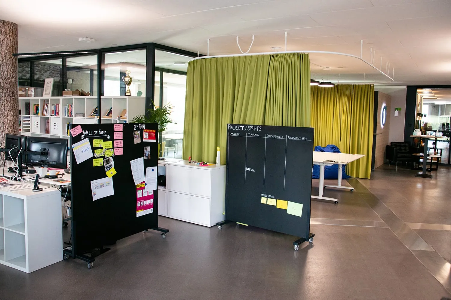 Mobile Whiteboards und Regale vor dem Akustikvorhang