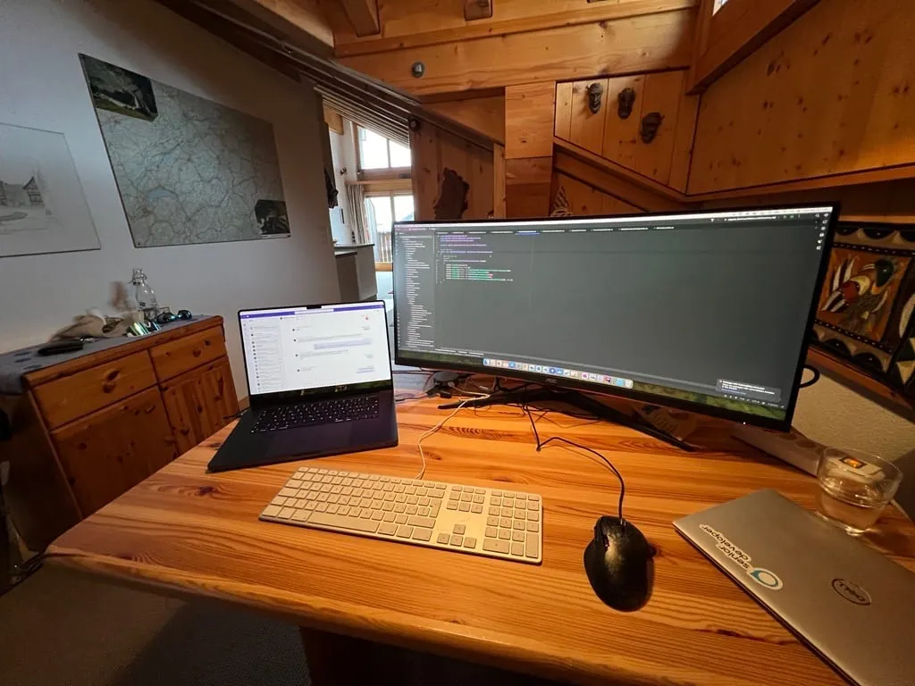 Arbeitsplatz in der Ferienwohnung: Laptop mit Breitbildmonitor auf einem Holztisch