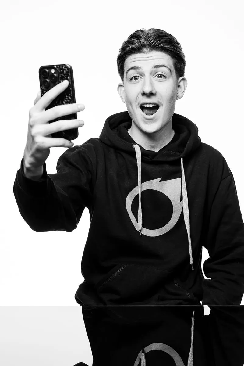 Schwarzweissaufnahme: der xappido-Lehrling macht ein Selfie mit dem Smartphone