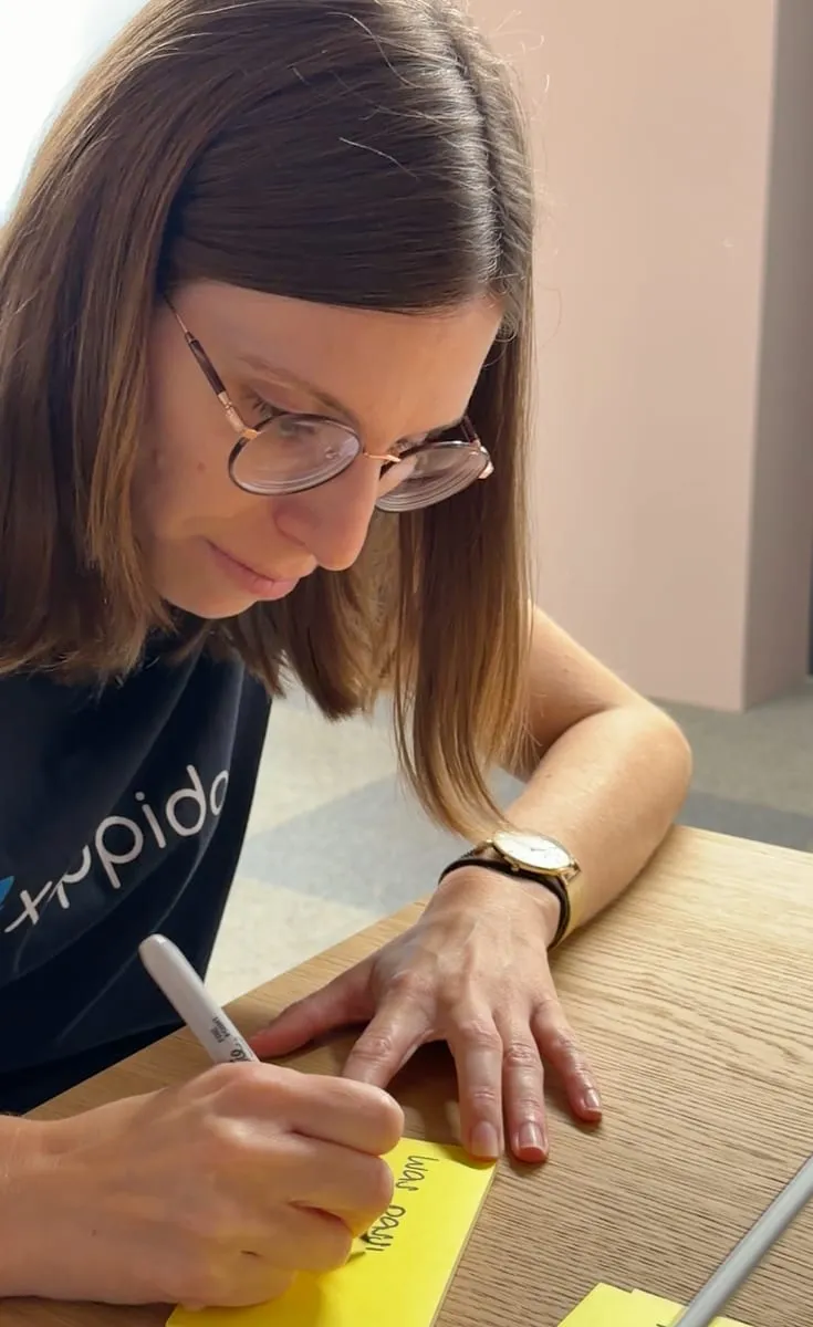 Workshop bei xappido: eine Teilnehmerin notiert Ideen auf gelben Haftzetteln