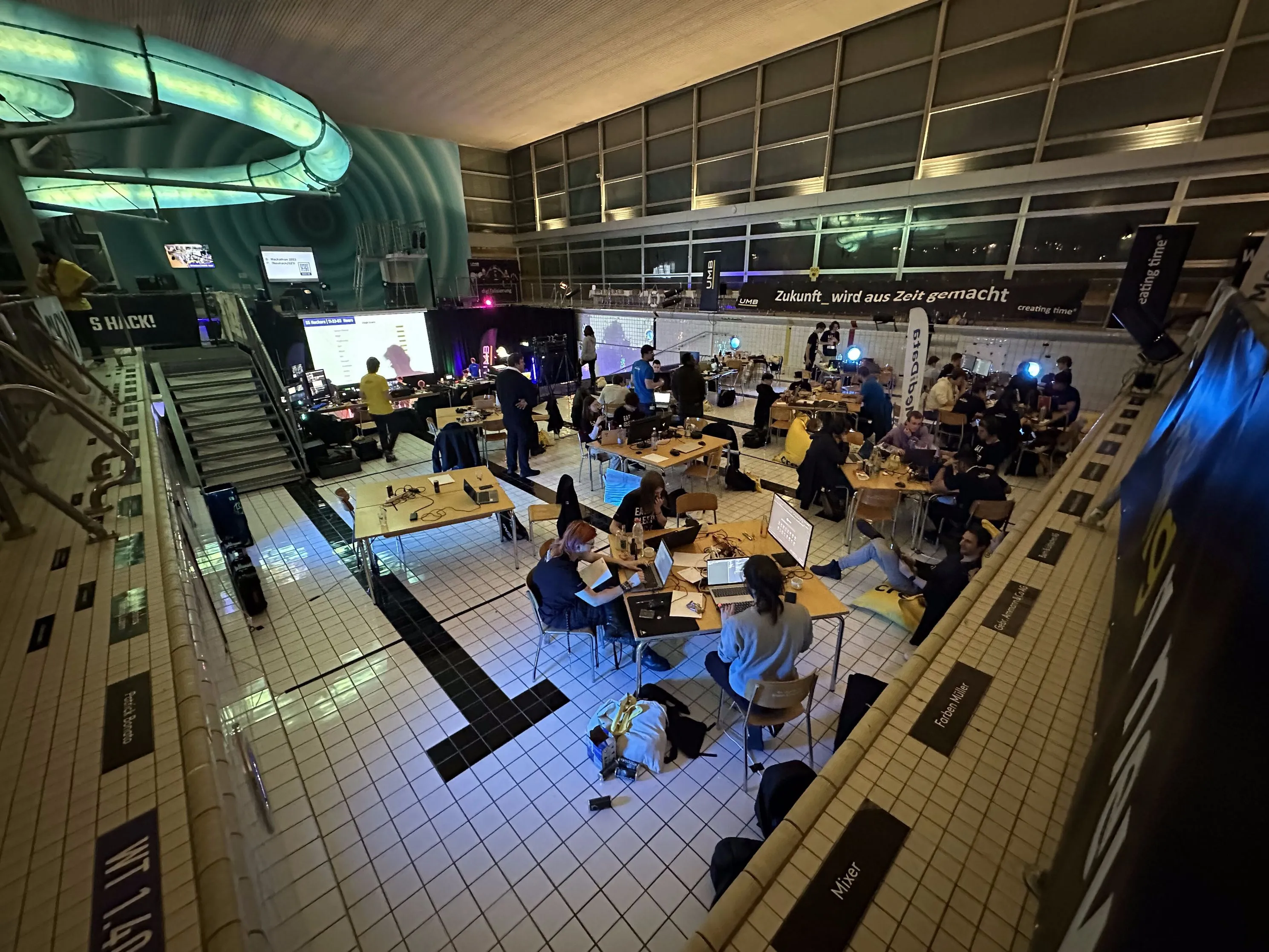 Blick in die Halle des Hackathons mit vielen Arbeitsplätzen