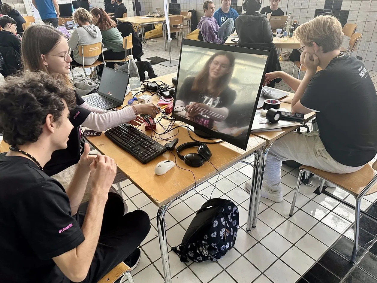 Ein Team bespricht sich an mehreren Bildschirmen