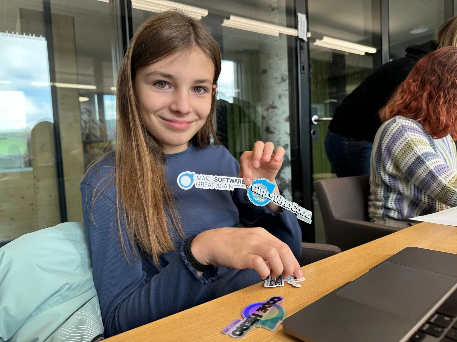 Eine Schülerin zeigt einen xappido-Sticker in die Kamera