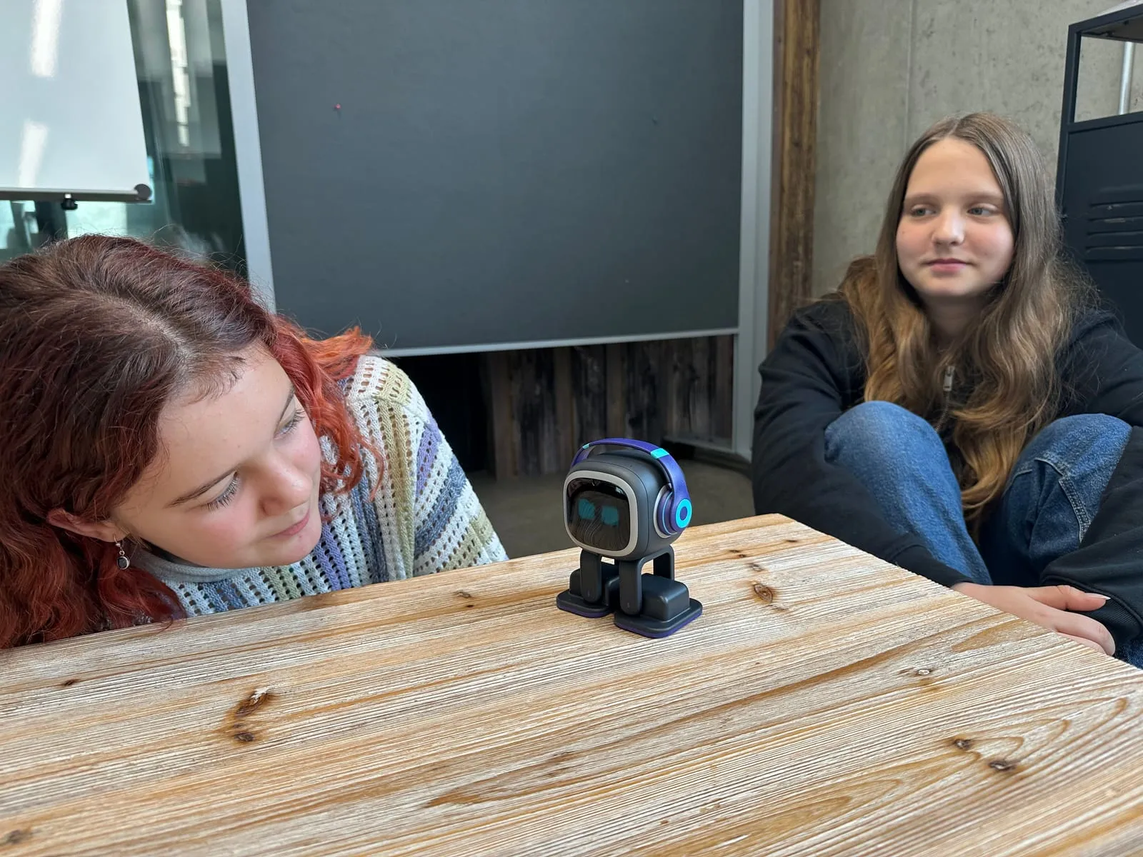Zwei Schülerinnen am Tisch mit dem Roboter Emo