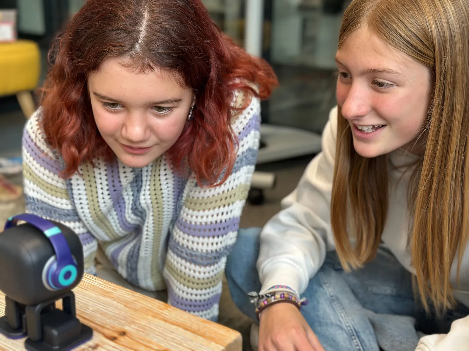 Zwei Schülerinnen betrachten den Roboter Emo