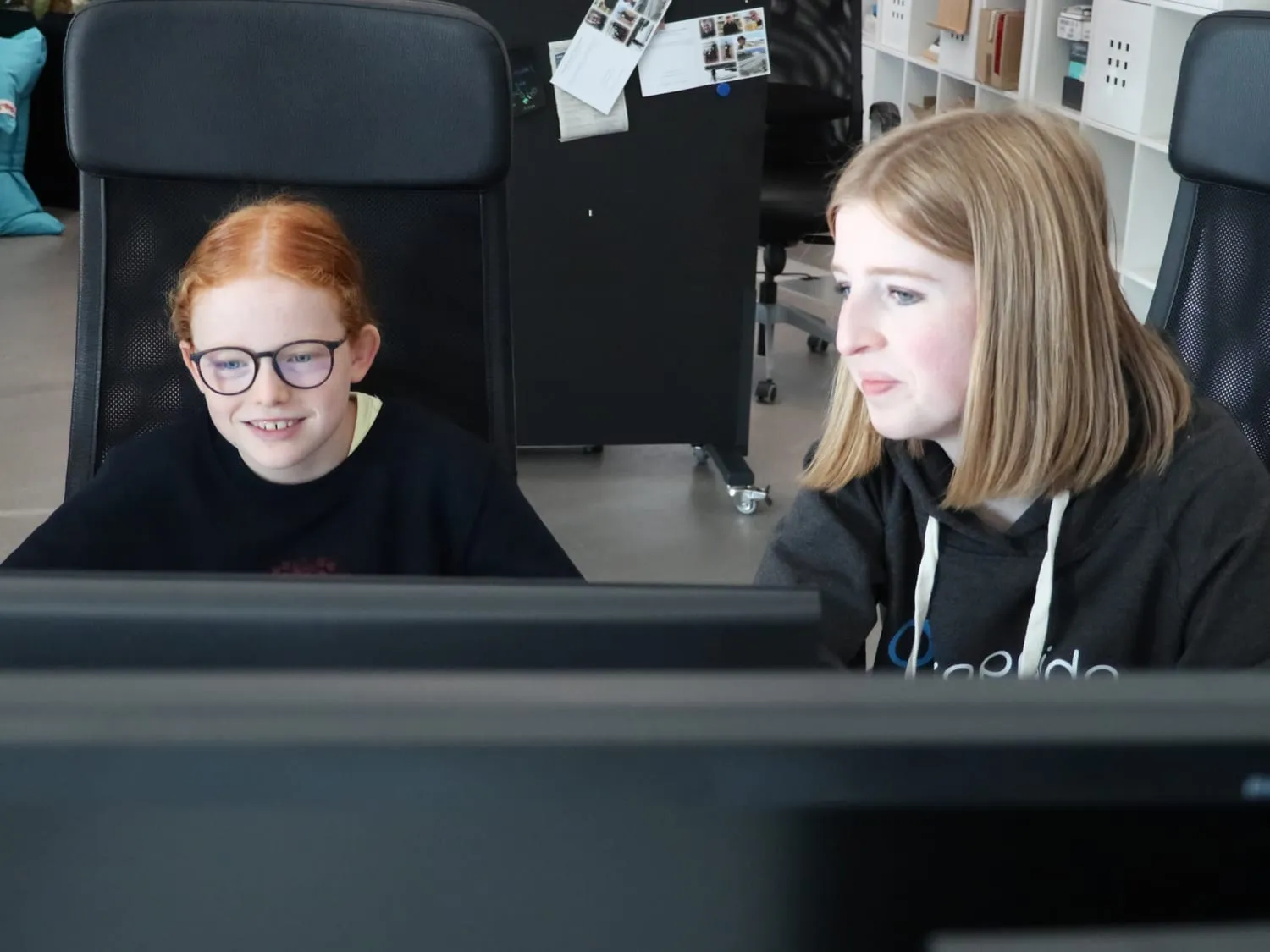 Zwei Teilnehmerinnen schauen gemeinsam auf einen Bildschirm
